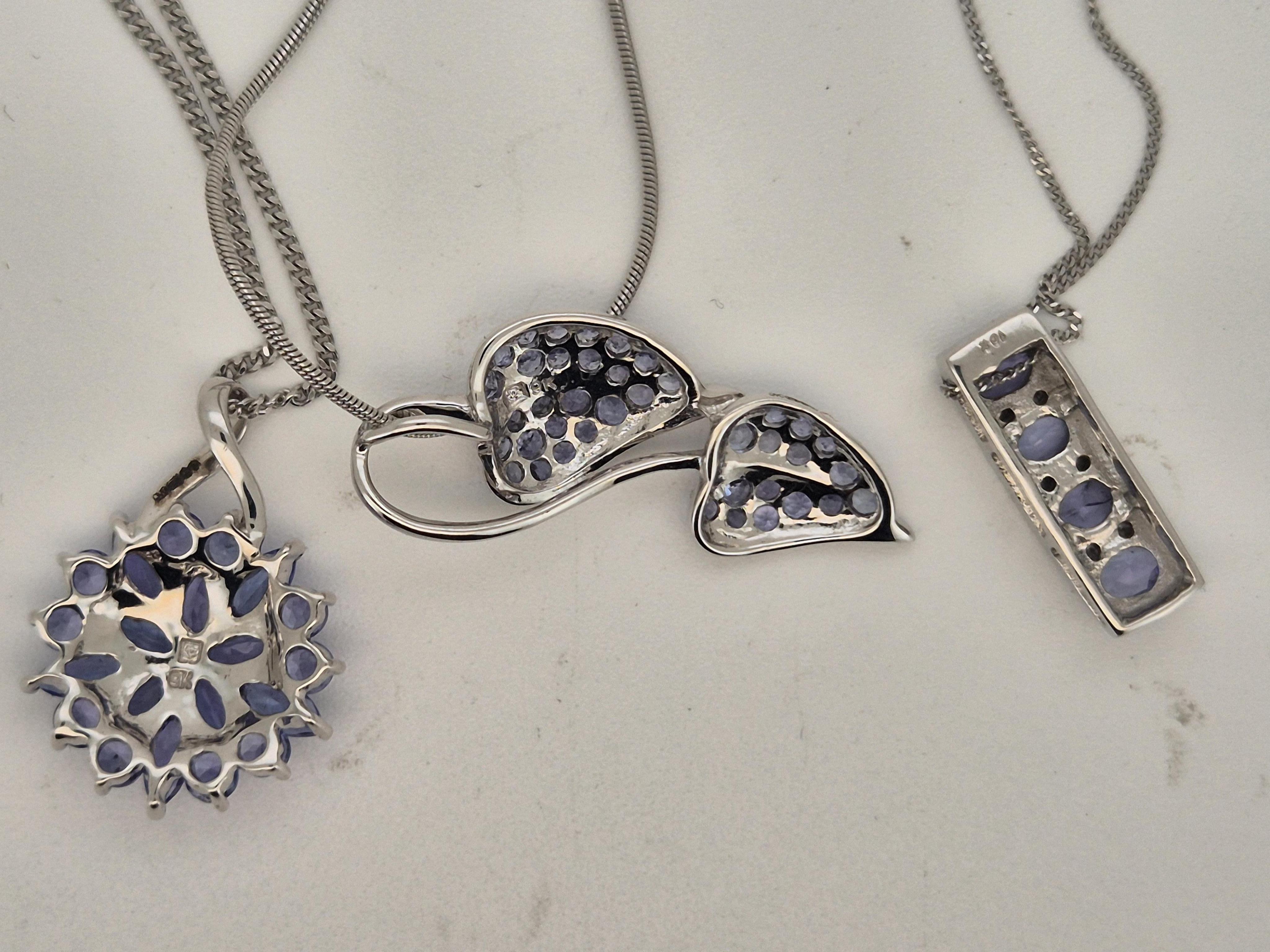 A modern 10k white metal, tanzanite and diamond chip cluster set line pendant, 17mm, on a white metal chain stamped 375, together with two other modern 9k white metal and tanzanite cluster set pendants, both on 9ct white